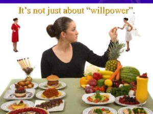 A woman sitting at the table with many different foods.