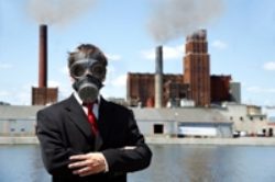 A man in a suit and gas mask standing next to a body of water.