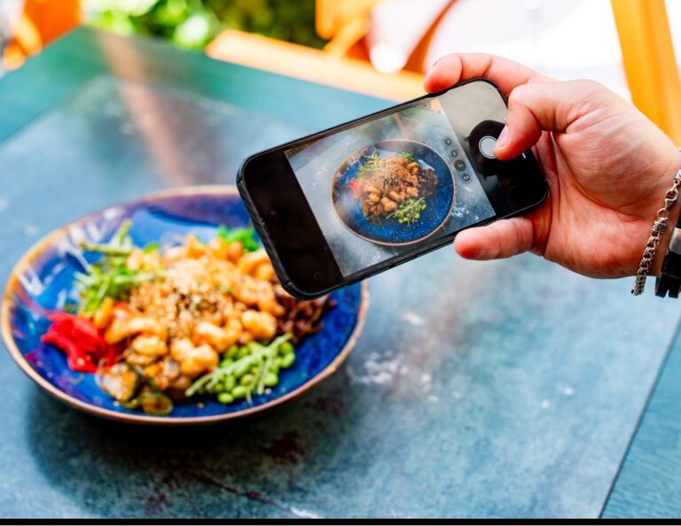Person photographing colorful, healthy meal on table.